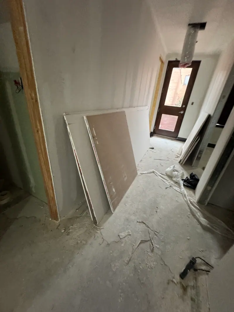 Austin interior under renovation with leftover drywall sheets on bare concrete
