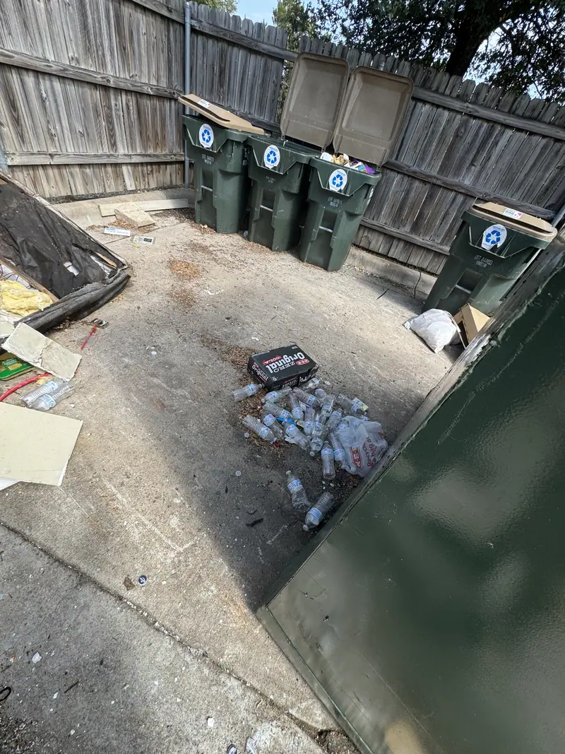 The same San Marcos trash enclosure cleared back to bare concrete with the carts standing upright